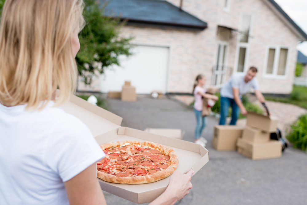 Woman carry pizza to her family outside